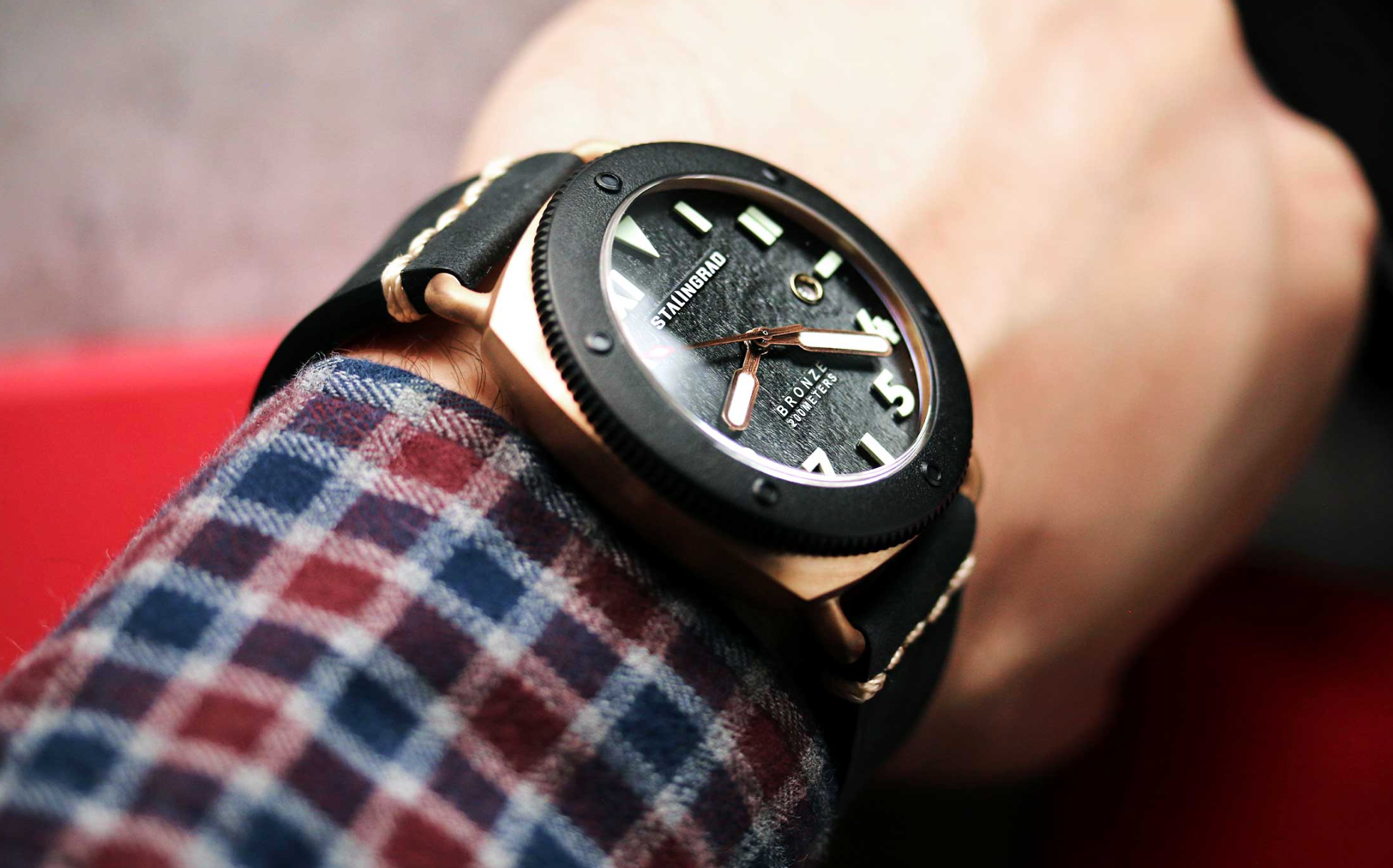 Bronze Watch 200m mens watch black dial on a mans wrist with a checkered shirt