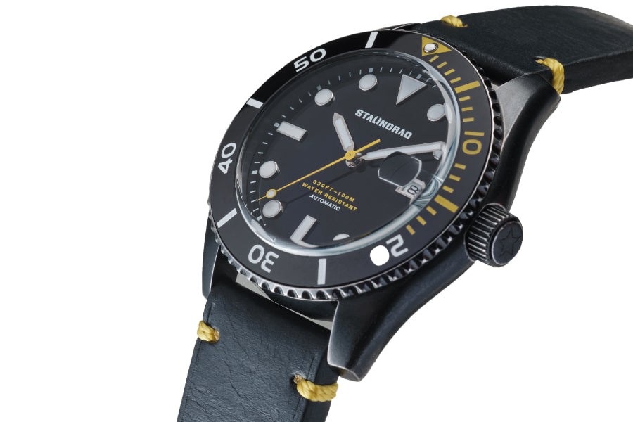 Stalingrad Volga defender automatic watch with a black case and black dial with yellow second hand in a black leather strap, diagonal view or watch on a white background