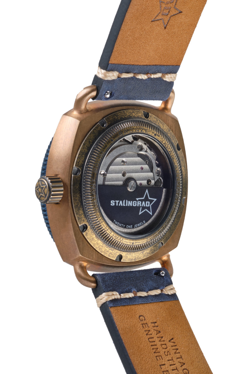 Stalingrad Bronze Defender 200m mens watch. Bronze case with a Blue dial and blue Bezel, on a blue leather strap. Showing the front of the watch on a white background Bronze case and display case back with a view of the watch movement inside on a white background