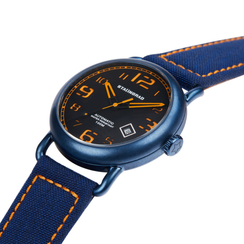 Stalingrad Rodim Watch with a sandwich dial. Black and orange dial, blue case and a blue cordura strap, diagonal view of watch on white background.