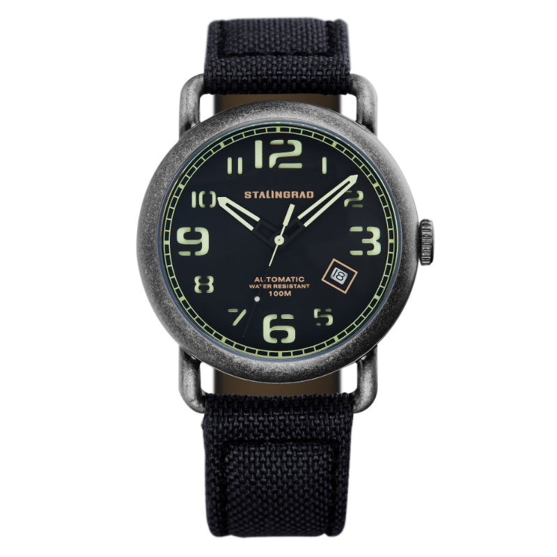 Stalingrad Rodim Watch with a sandwich dial. Black and green dial, black case and a black cordura strap, front view of watch on white background.